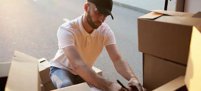A man writing on a box outside Brooklyn apartment 