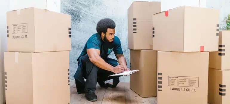 Man checking boxes and writing on clipboard 