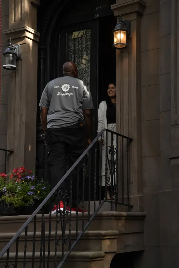 A customer and moving company employee talk in a doorway in New York City