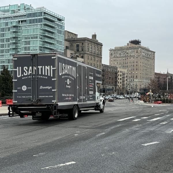 A moving truck driving across Brooklyn, NY
