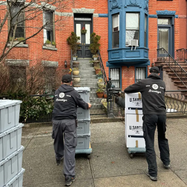 Employees of a moving company bring boxes to a Highland Park, Brooklyn home