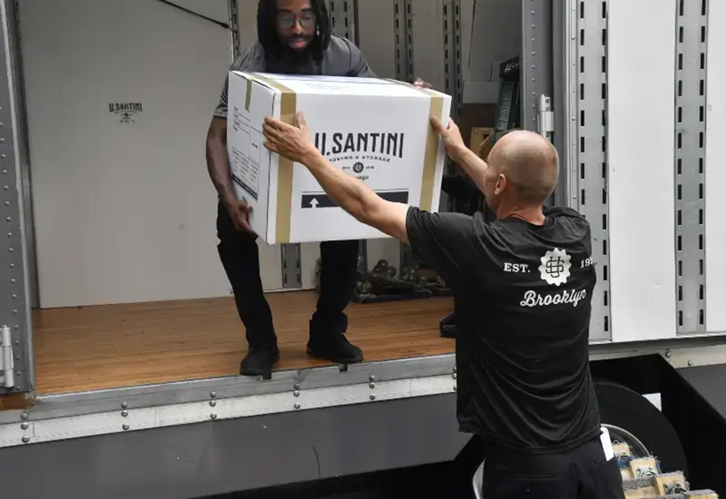 A moving company loads boxes into a truck in New York City