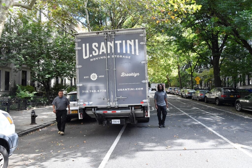 Two U.Santini workers preparing to open moving truck in Brooklyn