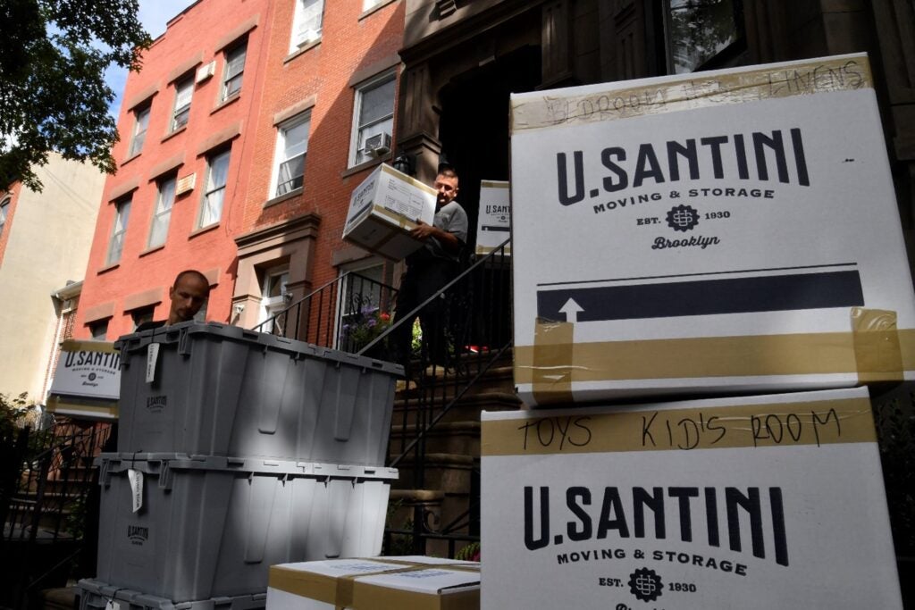 U.Santini movers stacking boxes outside a New York apartment