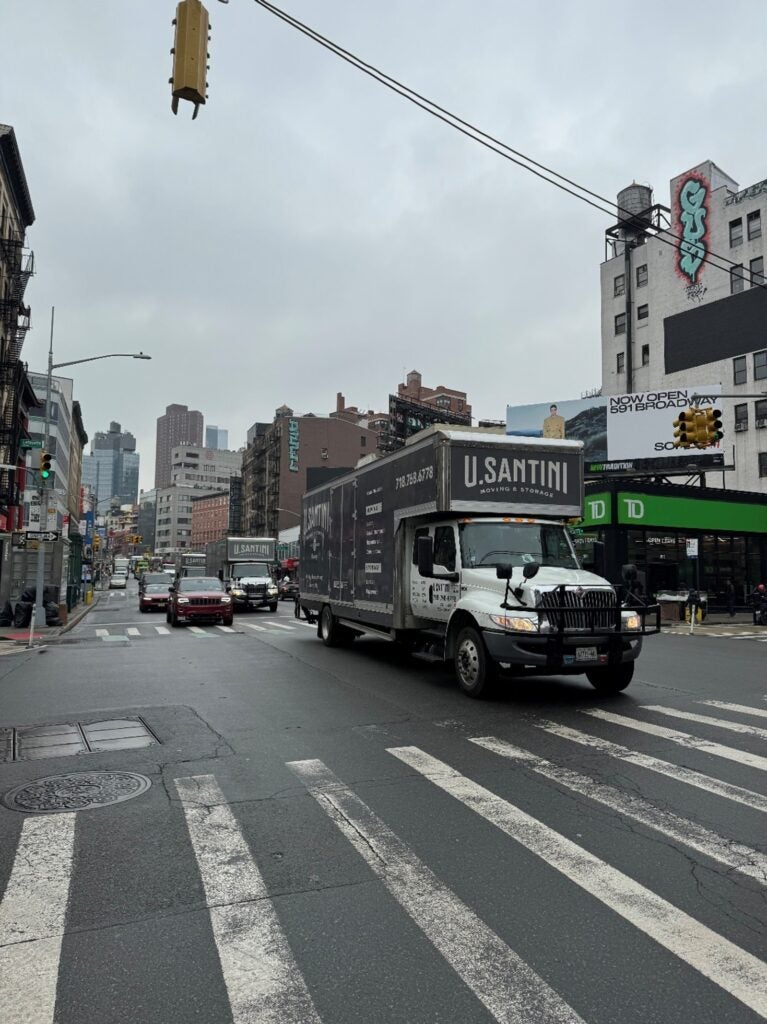 U.Santini moving truck going down a Brooklyn New York street