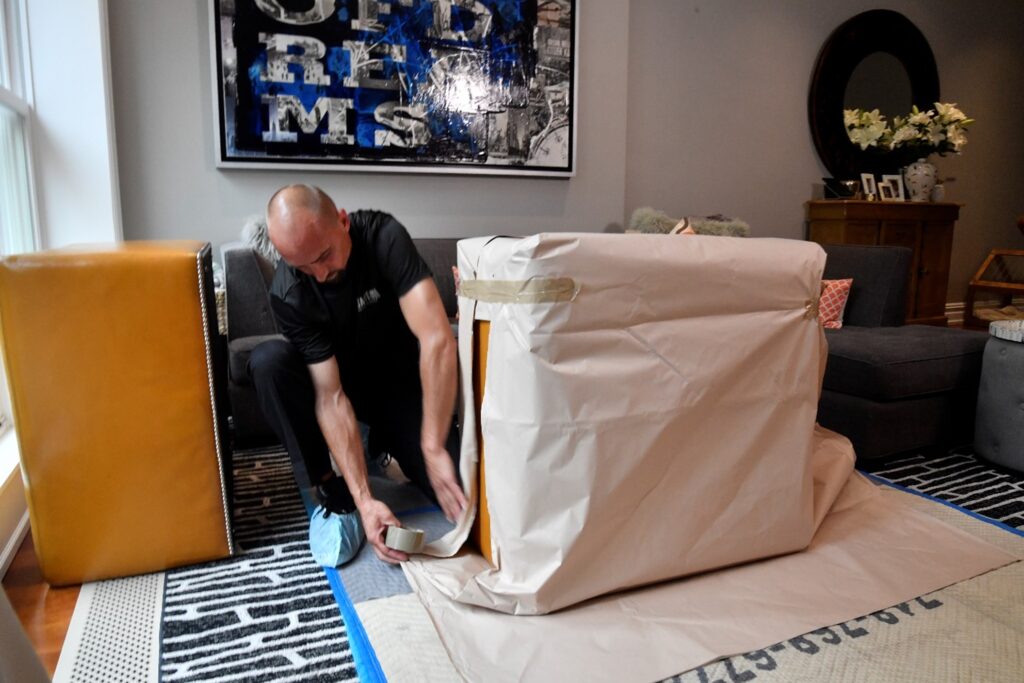U.Santini worker packing furniture with packing paper