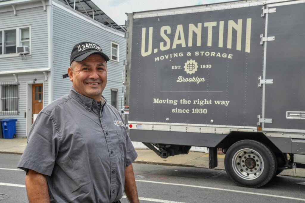 A person standing in front of a moving truck