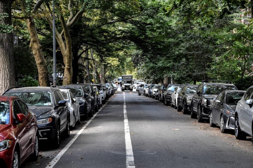 A row of cars parked on a street in the Upper West Side