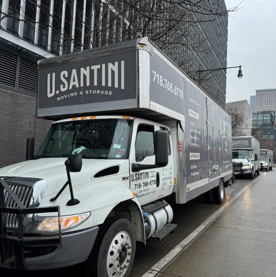 Three U.Santini trucks parked in Battery Park City, Manhattan with Freedom Tower in background