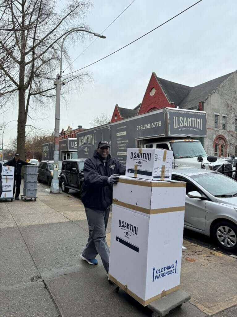 U.Santini workers moving boxes and carts down street in Upper West Side, Manhattan
