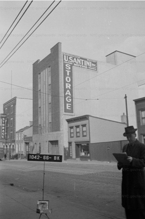 A black-and-white archival photograph of the U. Santini Inc. Moving & Storage building in Brooklyn, featuring a large vertical 