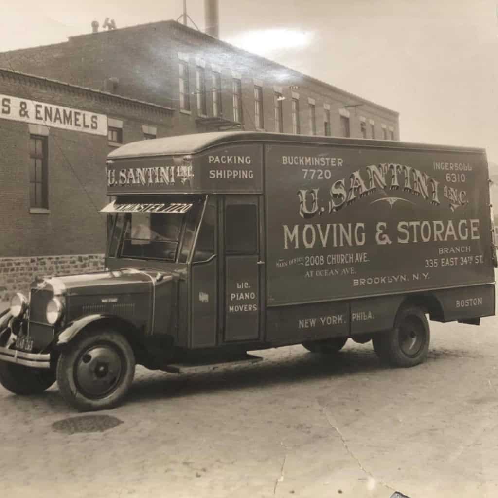 A historic black-and-white photograph of a U. Santini Inc. moving truck displaying packing, shipping, and piano moving services, with the Brooklyn main office address at 2008 Church Avenue