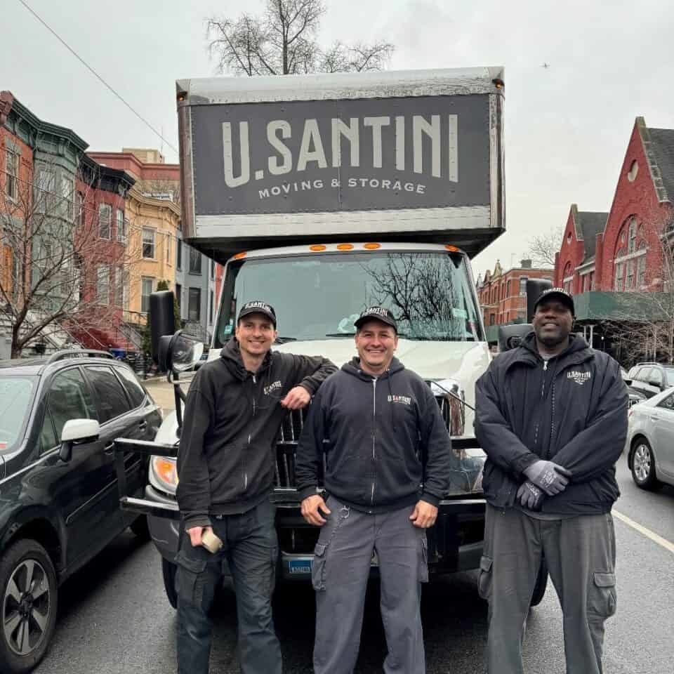 A U. Santini mover opening the rear doors of a large branded truck showing the company's established date of 1930 and the tagline 